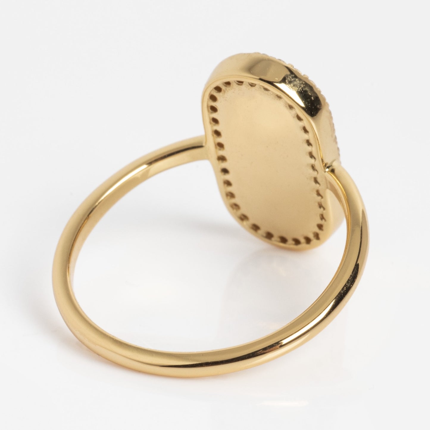 The So Art Deco Cocktail Ring features a thin gold band and an oval, flat top with dotted detailing along the edge, shown against a white background.