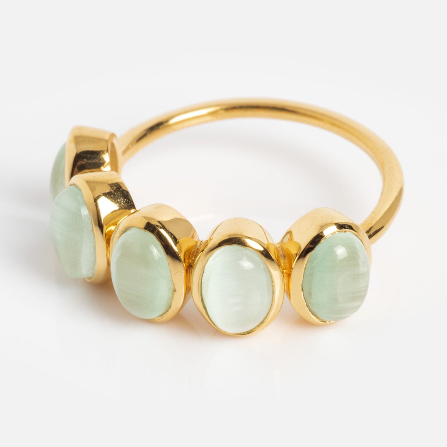 The Sky Blue Cats Eye Flow Ring features five oval, pale green gemstones set side by side in bezel settings, displayed on a white background.