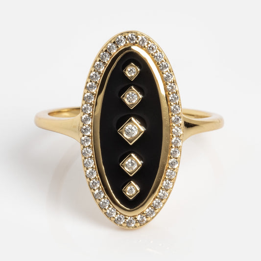 The Velvet Noir Navette Ring is a gold ring with an elongated oval face, a black center, four vertically set diamond-shaped diamonds, and a border of small round diamonds around the black area.