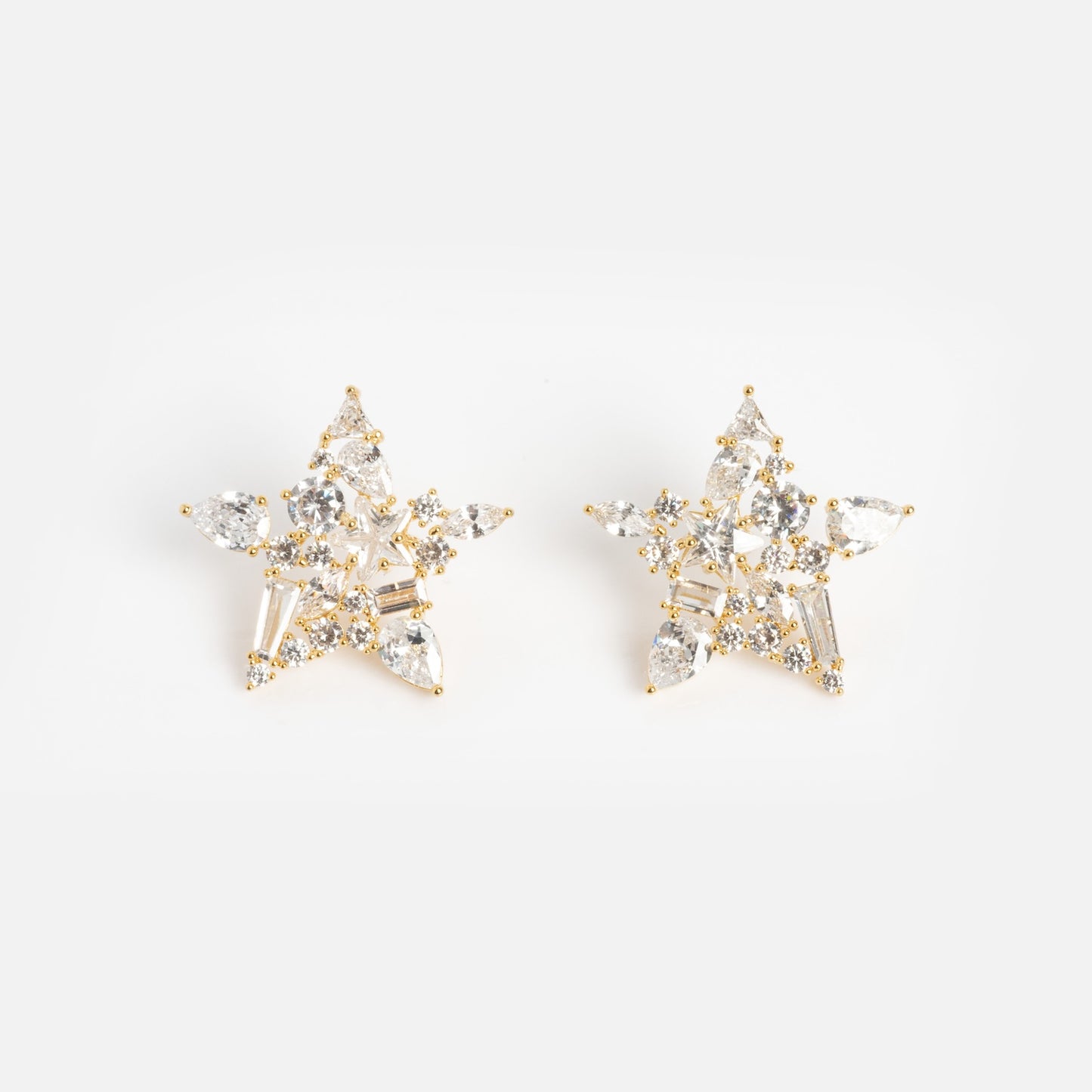 Debut Star Stud Earrings: Gold, star-shaped studs adorned with clear sparkling gemstones, shown on a white background.