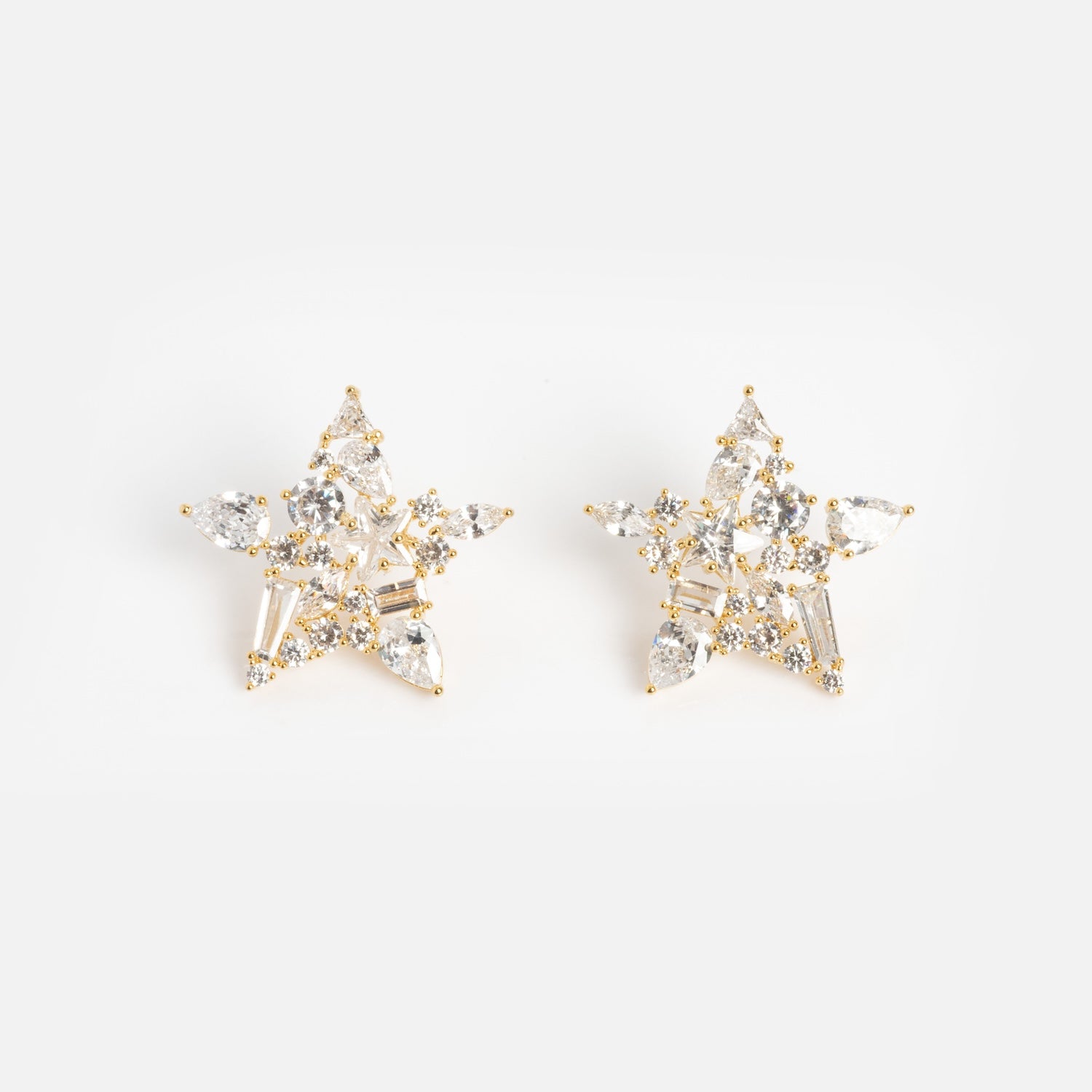 Debut Star Stud Earrings: Gold, star-shaped studs adorned with clear sparkling gemstones, shown on a white background.