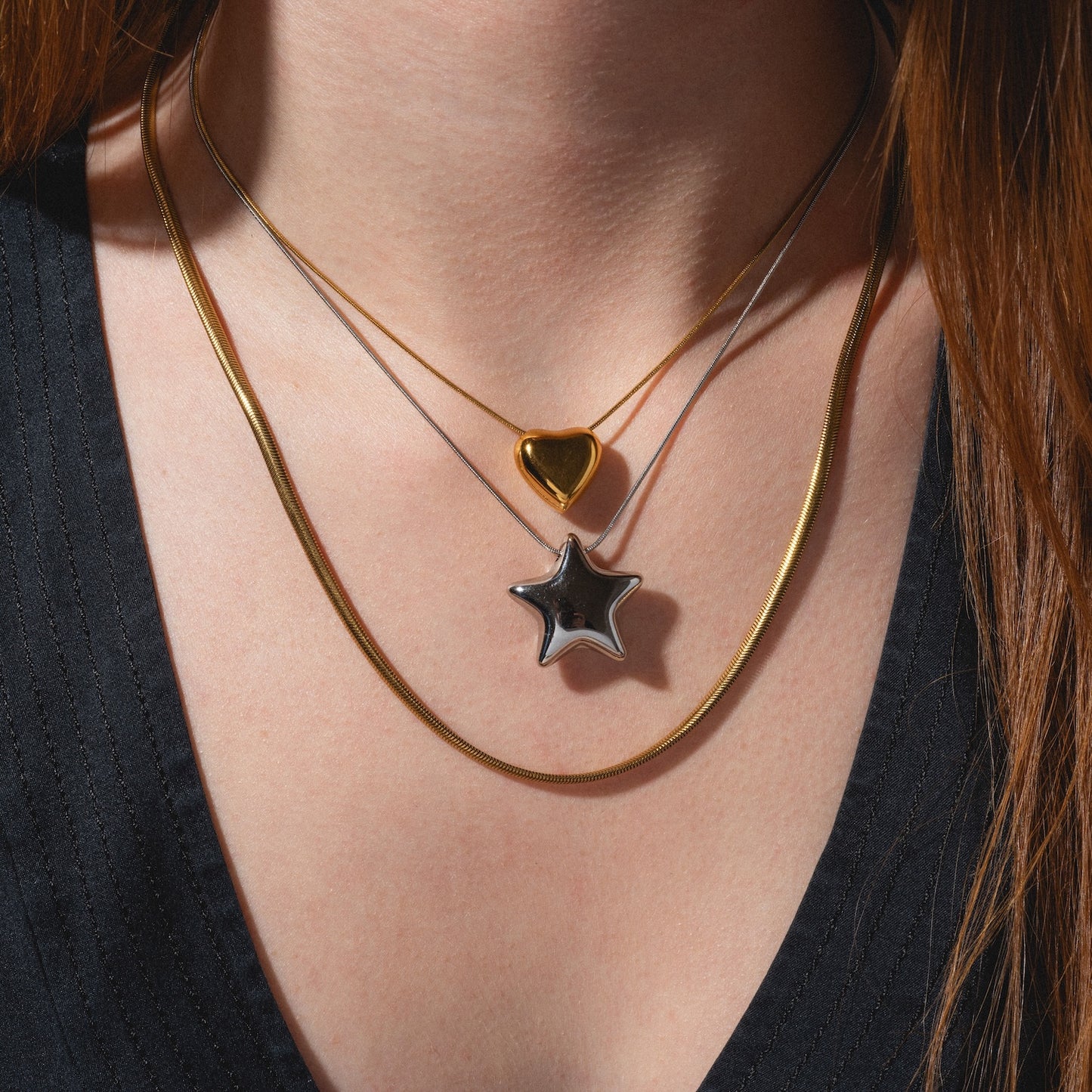A close-up of a person wearing the Yellow Necklace over a black V-neck top.