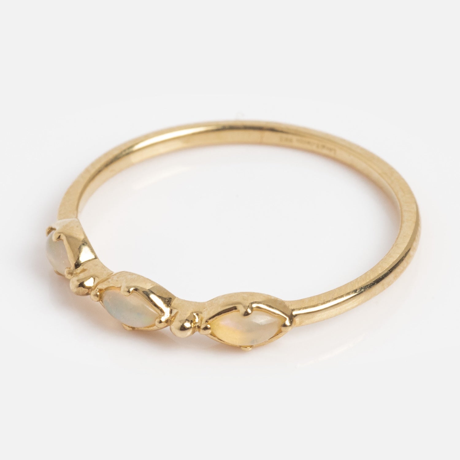 The Solid Gold Dainty Opal Trio Stacking Ring features three small oval opals set in minimalist gold bezels, displayed on a plain white background.