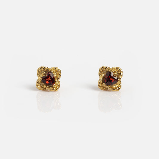 The Lover's Knot Heart Studs are gold earrings with round, deep red gemstones set in ornate, twisted gold frames, displayed against a plain white background.