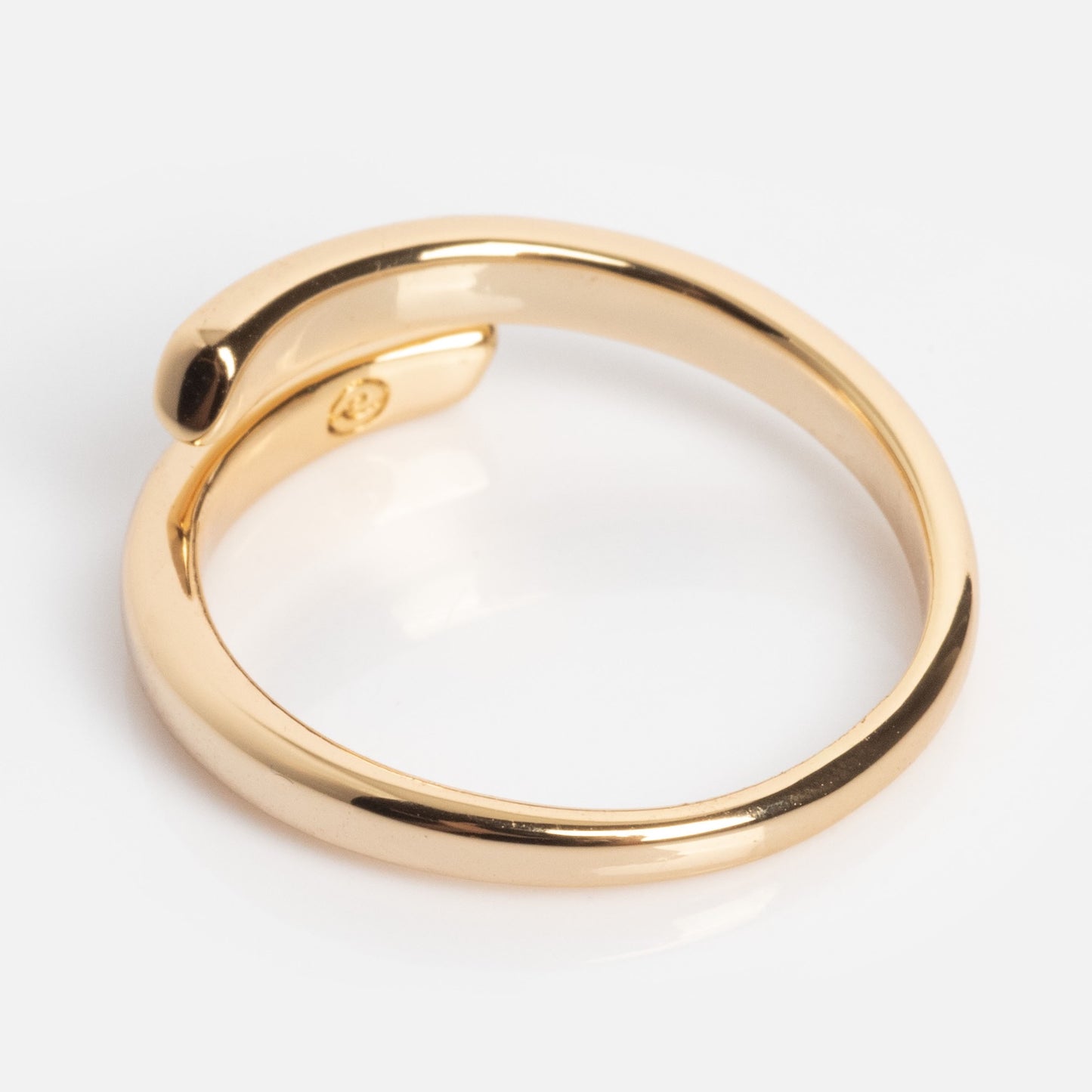 The Wrap Around Ring features a modern, open-ended gold design with one end slightly overlapping the other, shown against a white background.