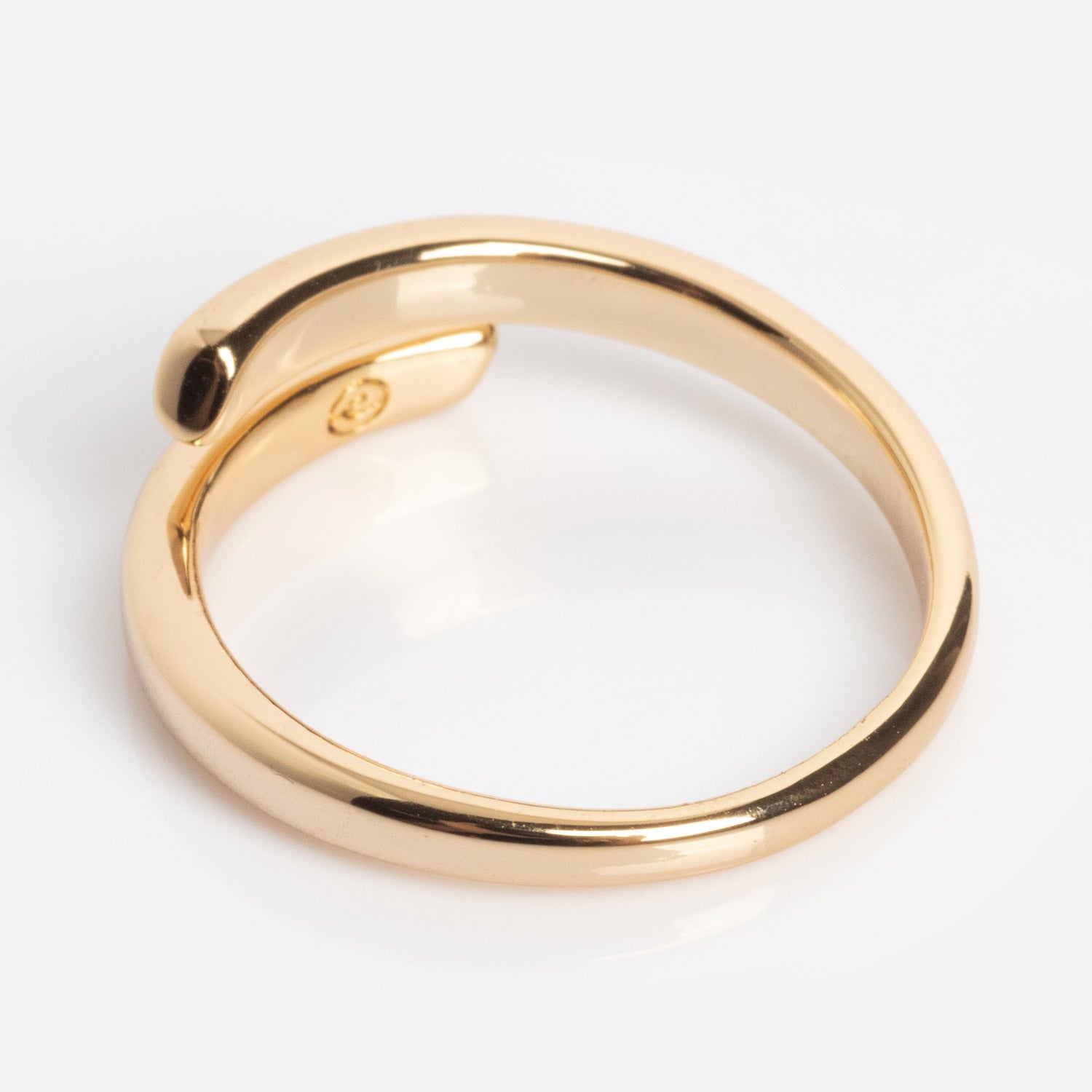 The Wrap Around Ring features a modern, open-ended gold design with one end slightly overlapping the other, shown against a white background.