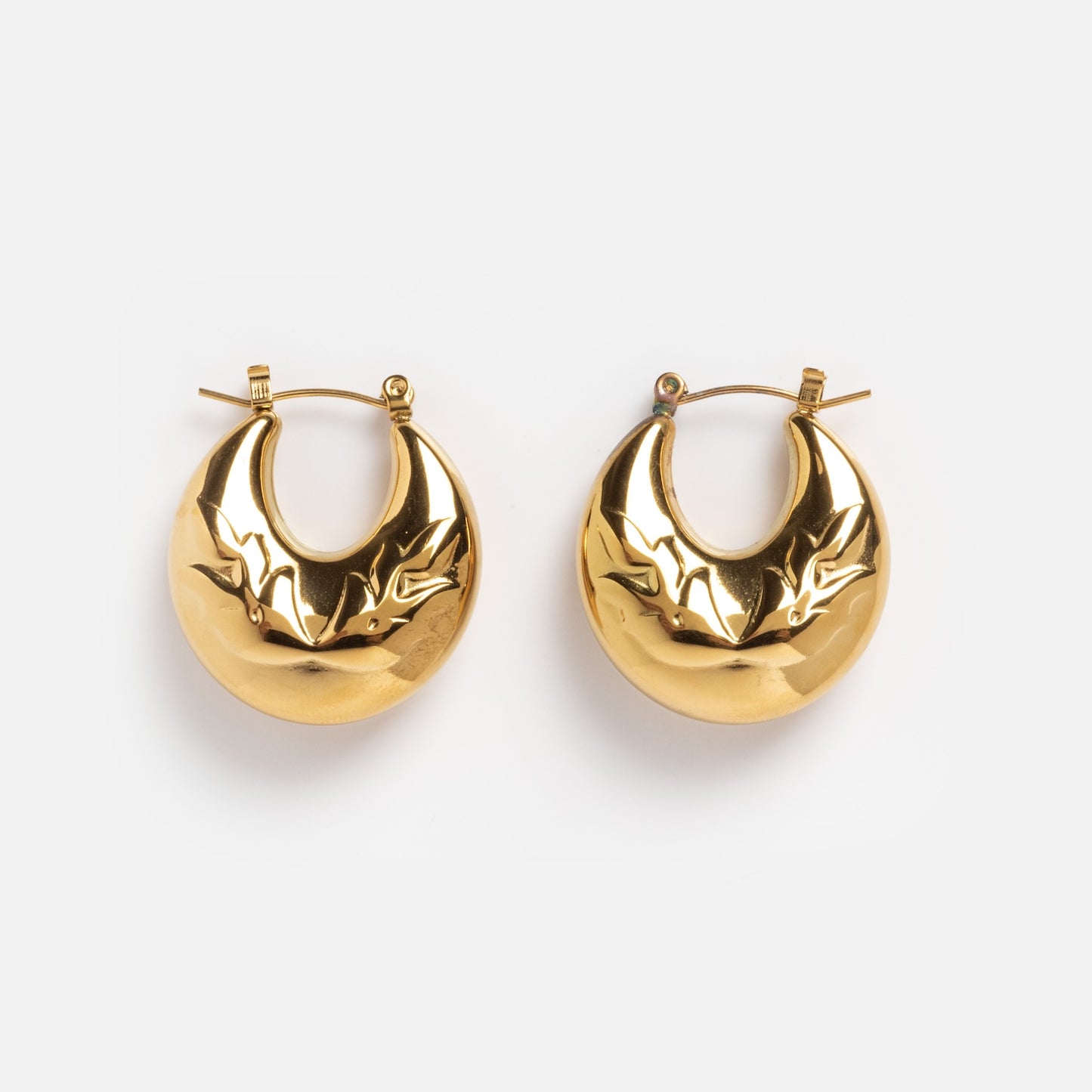 Goldie Earrings: Gold hoop earrings in a crescent moon shape with engraved star designs, shown on a plain white background.