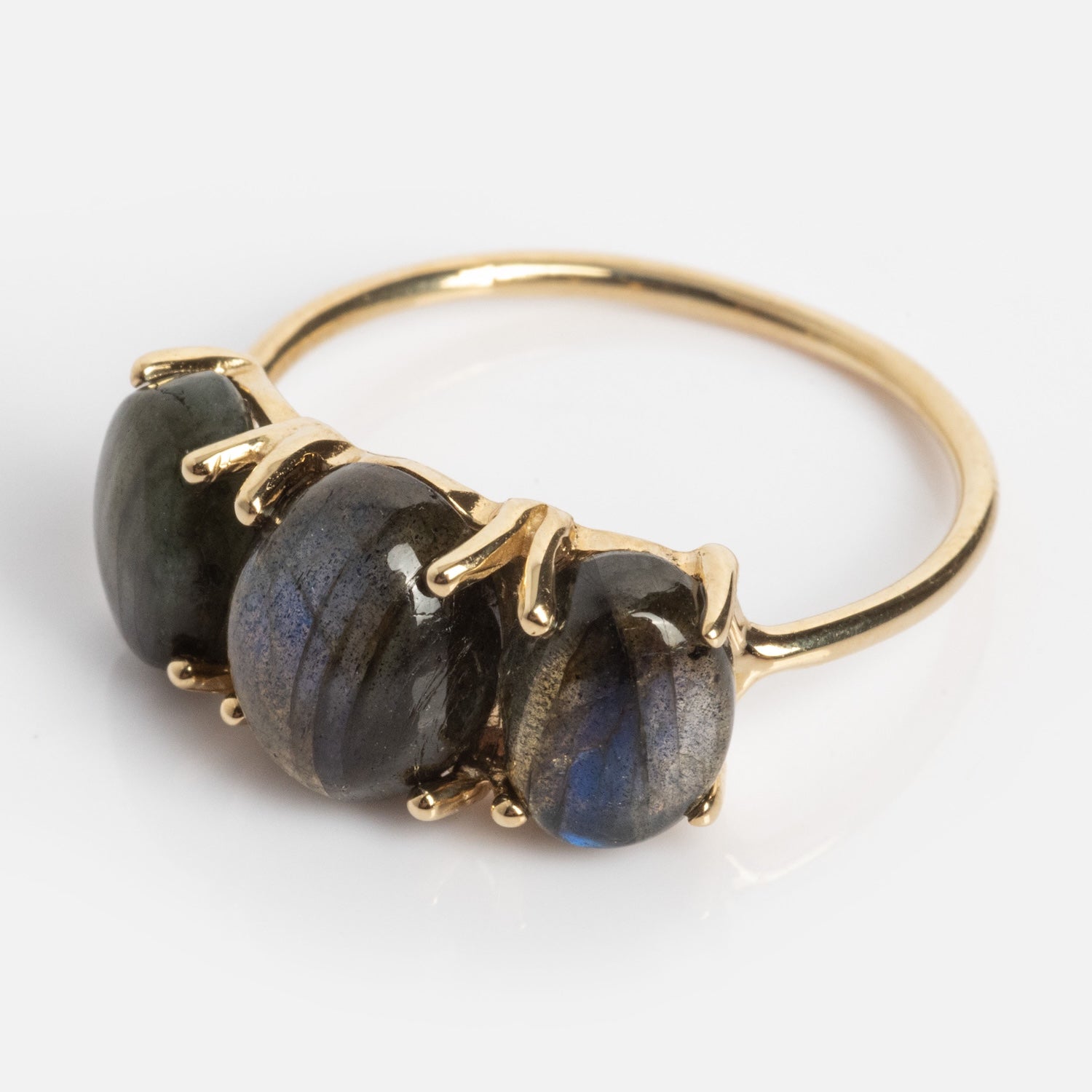 The Sweetest Gumdrop Ring is crafted from solid yellow gold and showcases three oval, dark blue-gray natural gemstones in prong settings, displayed on a white background.