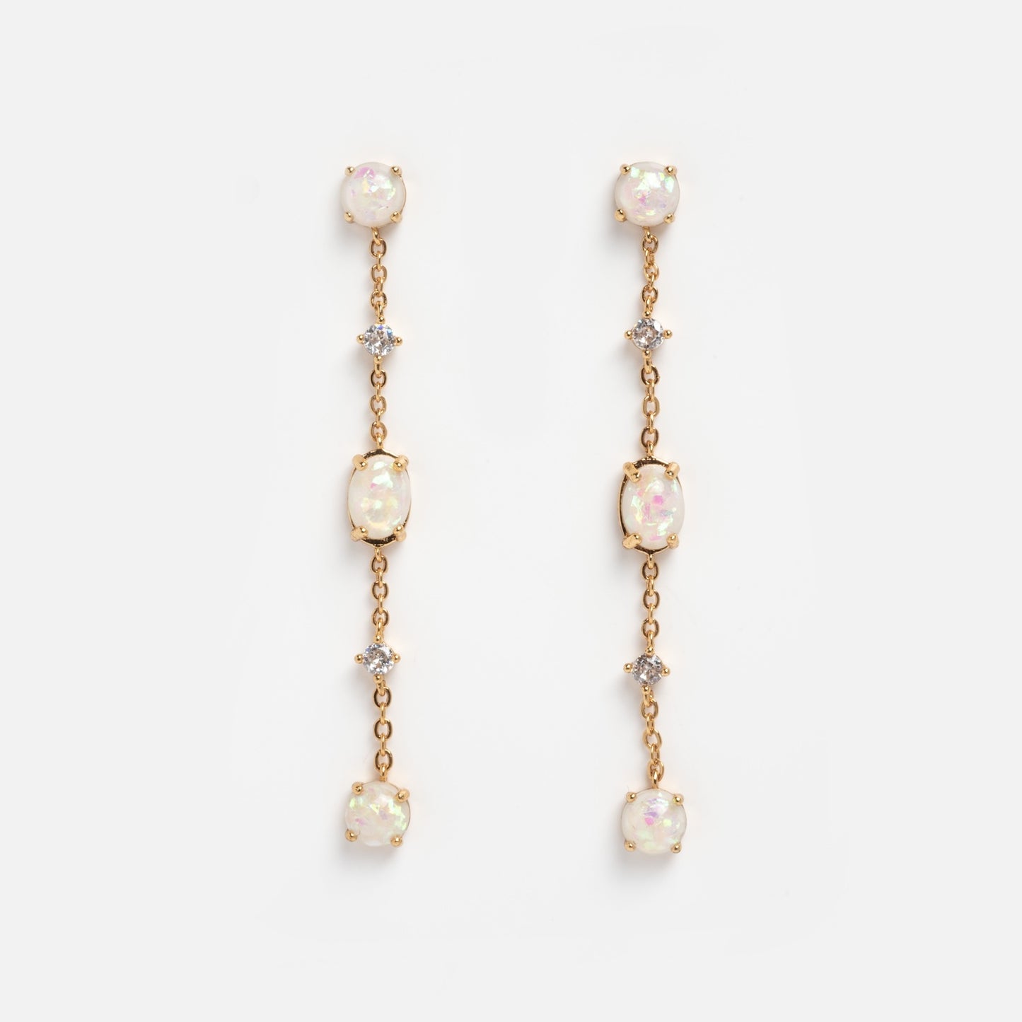 The Elegant Opal Sway Dangle Earrings feature three round opal-like stones and two small clear crystals arranged vertically on a delicate gold chain, displayed against a plain white background.