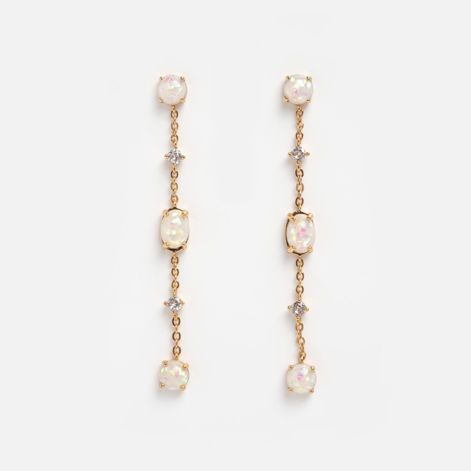 The Elegant Opal Sway Dangle Earrings feature three round opal-like stones and two small clear crystals arranged vertically on a delicate gold chain, displayed against a plain white background.