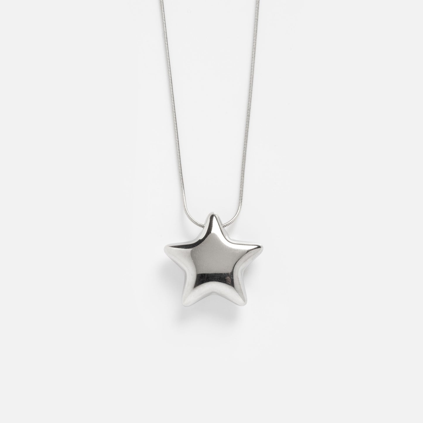 The Prism Necklace features a silver star-shaped pendant suspended from a delicate chain, displayed against a plain white background.