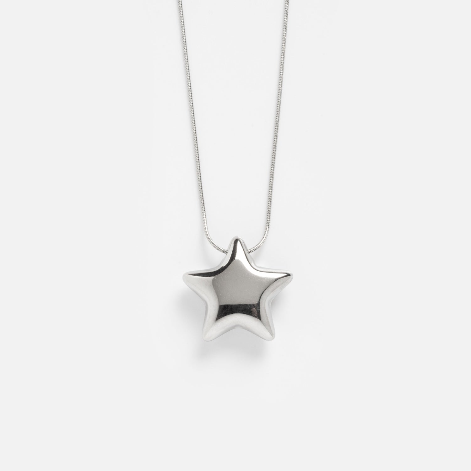 The Prism Necklace features a silver star-shaped pendant suspended from a delicate chain, displayed against a plain white background.