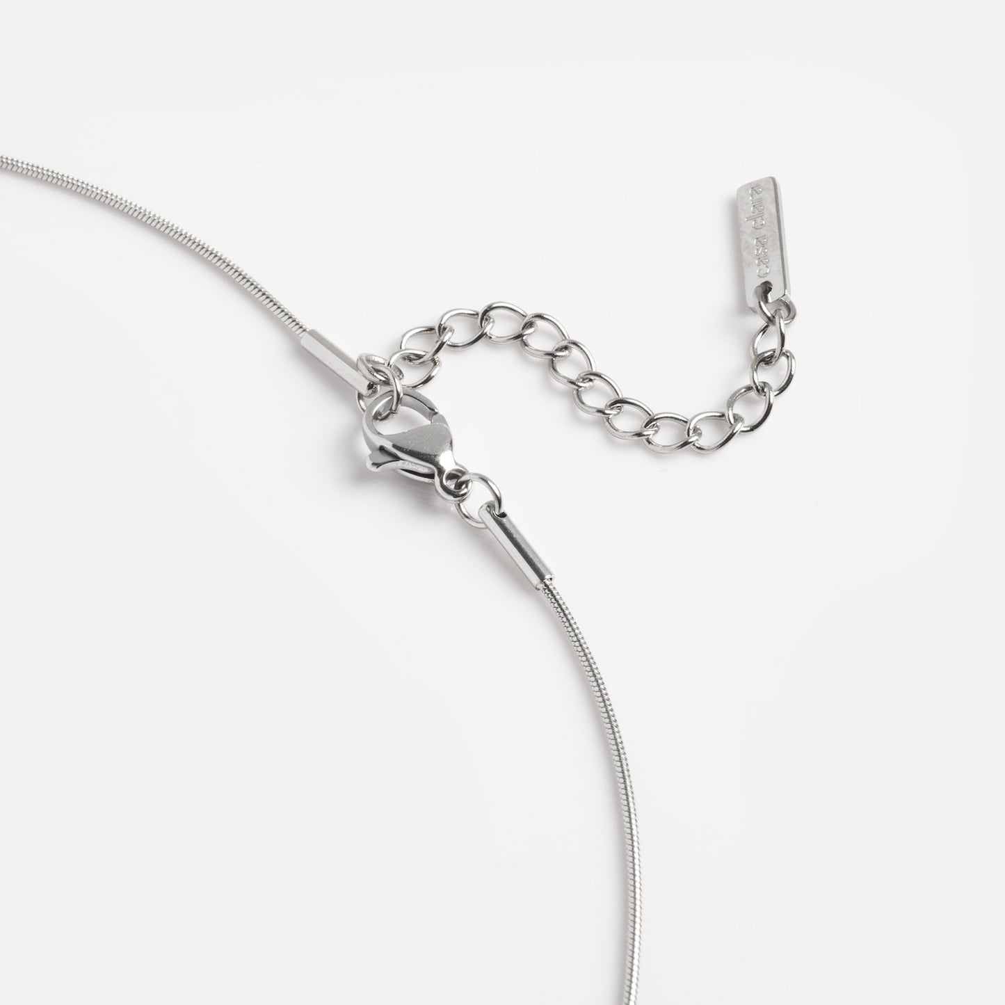 Close-up of the Prism Necklace, featuring a silver lobster clasp and adjustable chain extension, displayed against a plain white background.