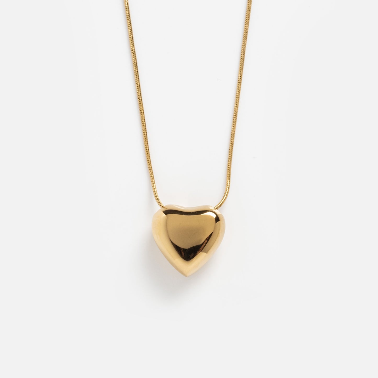 The Yellow Necklace features a shiny, smooth heart-shaped pendant in gold, displayed against a plain white background.