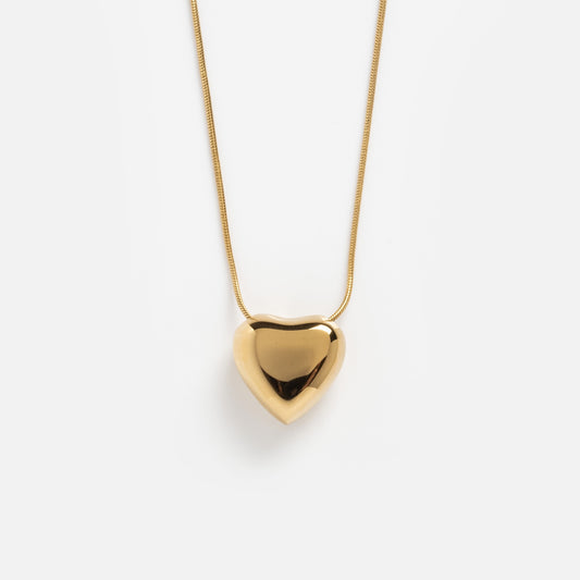 The Yellow Necklace features a shiny, smooth heart-shaped pendant in gold, displayed against a plain white background.