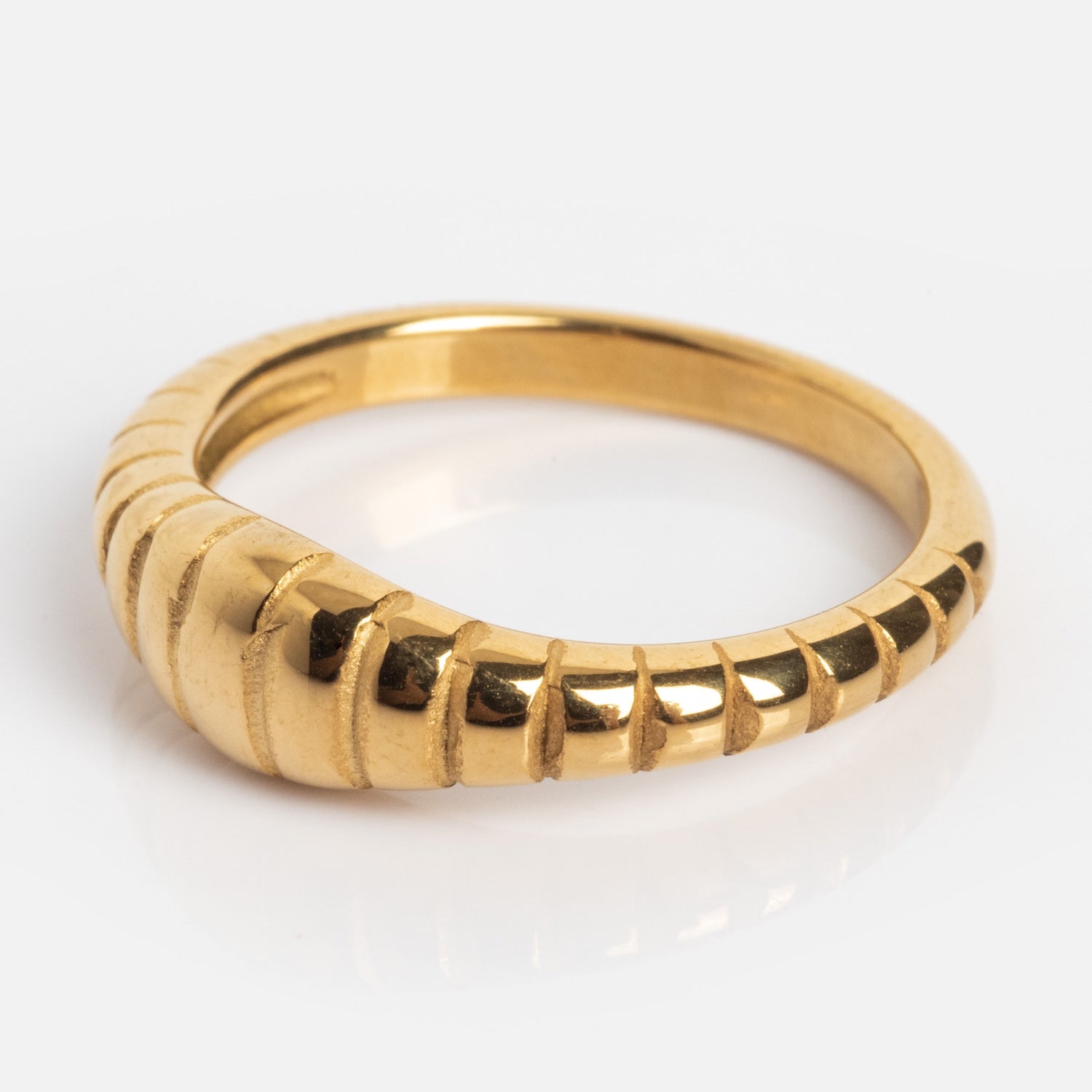 The Crew Ring features a unique gold design with ridges on one side that taper smoothly toward the other, shown against a white background.