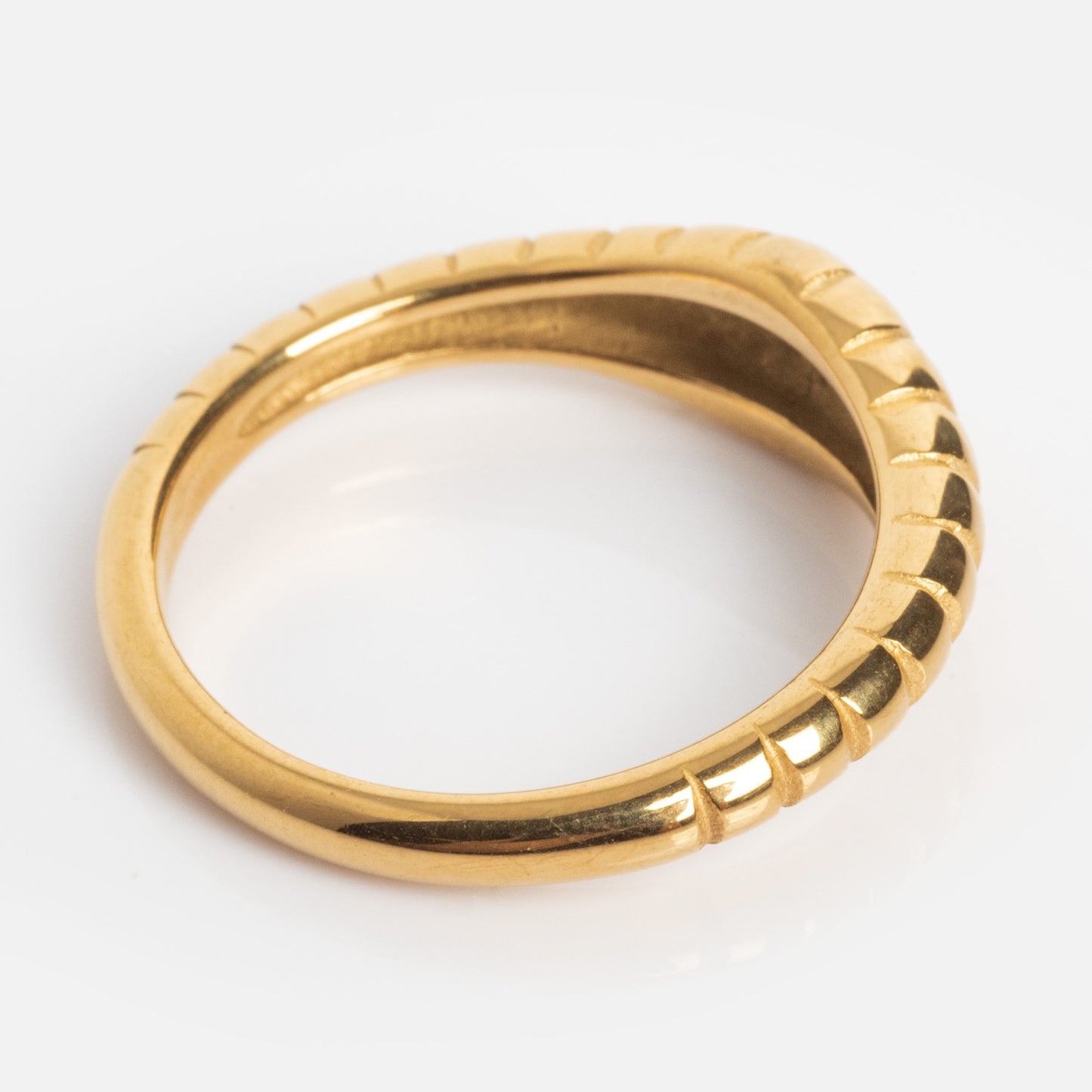 The Crew Ring features a gold, slightly irregular asymmetric shape with a ridged pattern along one side, shown against a white background.