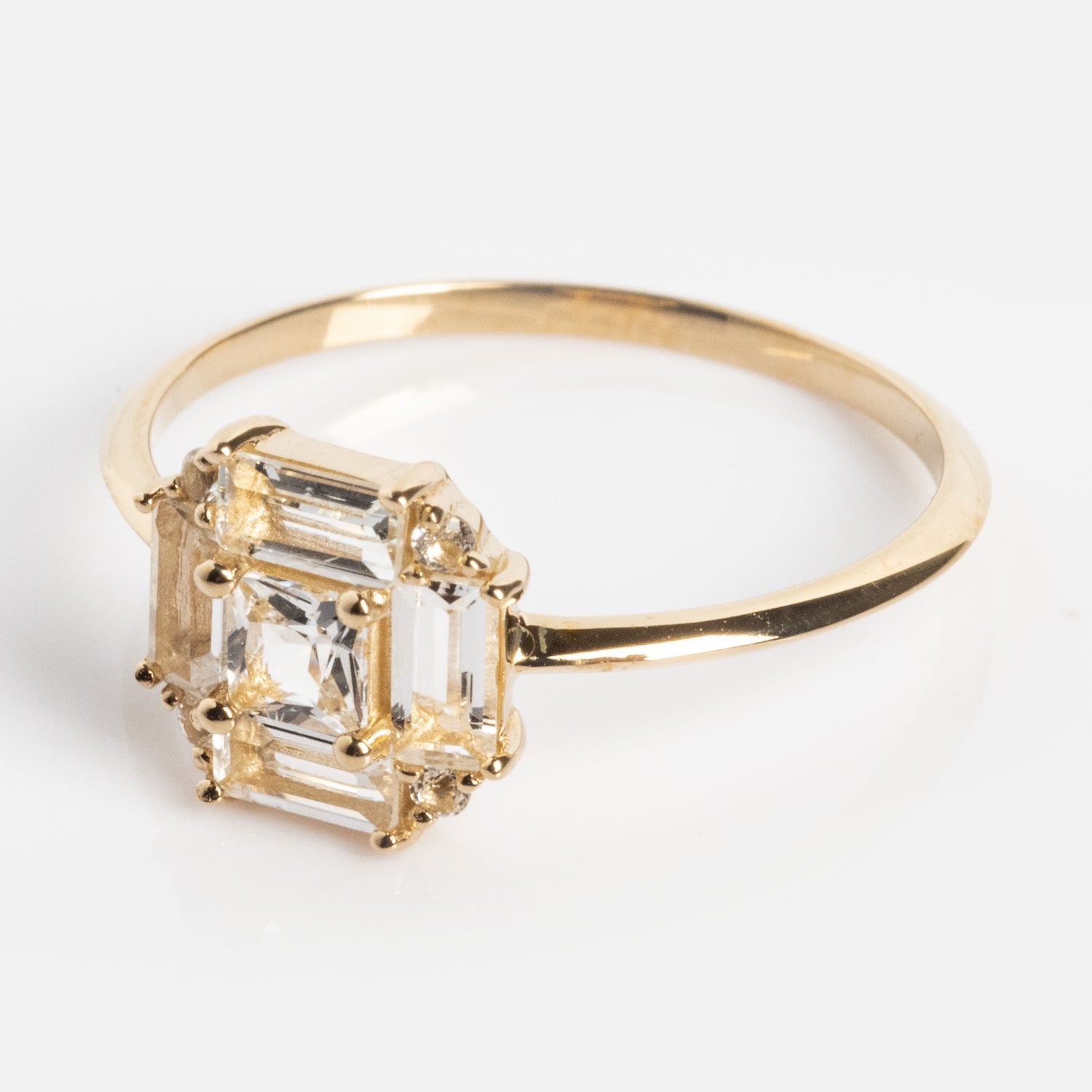 The 14k Vintage Inspired Art Deco Engagement Ring features a large emerald-cut clear gemstone in a six-prong setting on a thin 14k recycled gold band, shown against a white background.