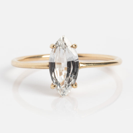 The Solid Gold Gemstone Marquise Ring in White Topaz features a vertically set marquise-cut white topaz in a four-prong solid gold setting, showcased against a simple white background.