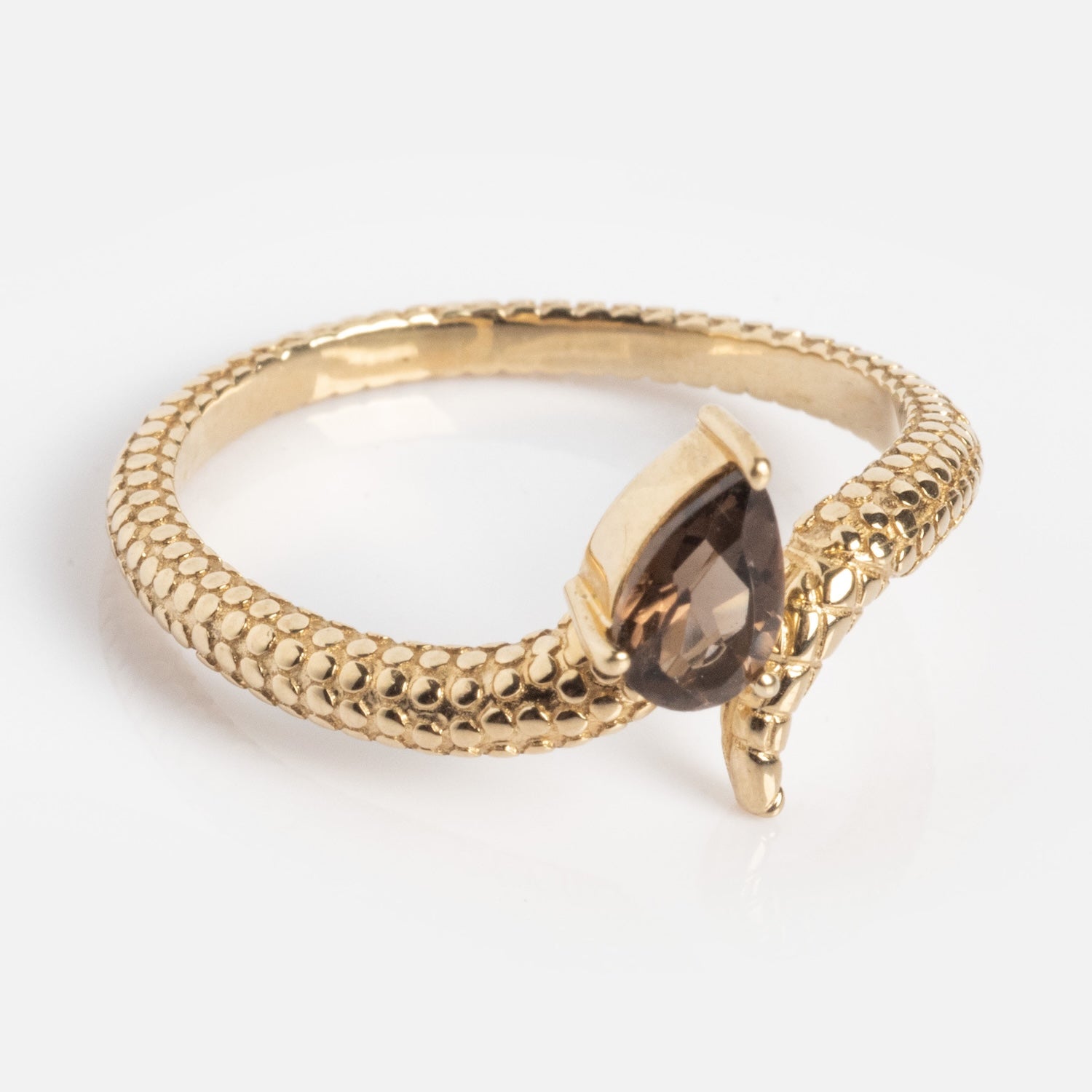 The Solid Gold Smoky Quartz Snake Ring for Transformation features a textured, scale-like band and a teardrop-shaped brown gemstone in a claw setting—an exclusive blend of elegance and serpentine allure.