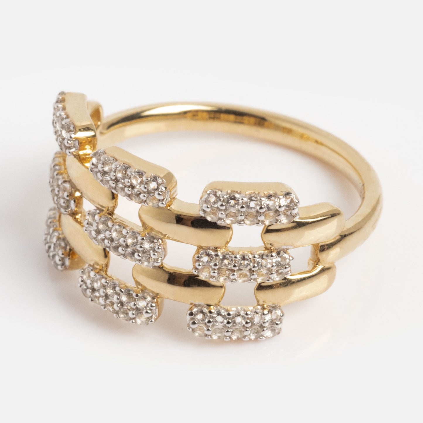 The Solid Gold Mirrored Light Diamond Statement Ring features a distinctive interlocking rectangular link design, partially encrusted with small clear stones, and is showcased on a white background.