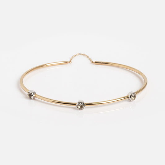 The Solid Gold Geometric Glimmer Mixed Metal Bracelet showcases three small silver hexagonal accents, each with a clear stone, against a plain white background.