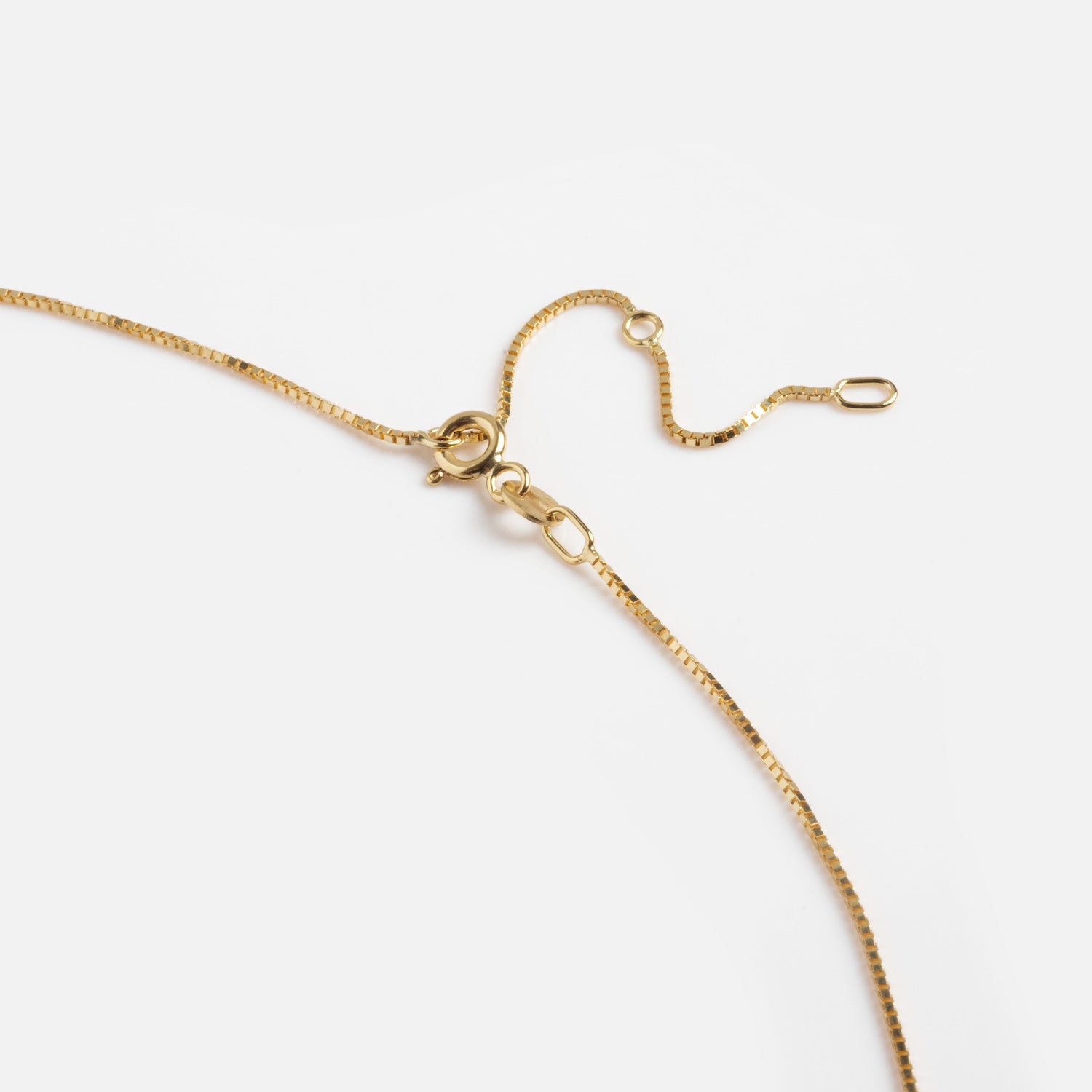 A close-up of the Solid Gold Box Chain necklace in 9k solid gold, featuring a small lobster clasp and adjustable links, displayed on a plain white background.