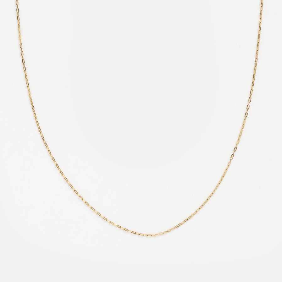 The Solid Gold Delicate Paperclip Chain features small, evenly spaced links in solid gold. Perfect for a subtle statement or layering, the necklace is displayed against a plain white background.