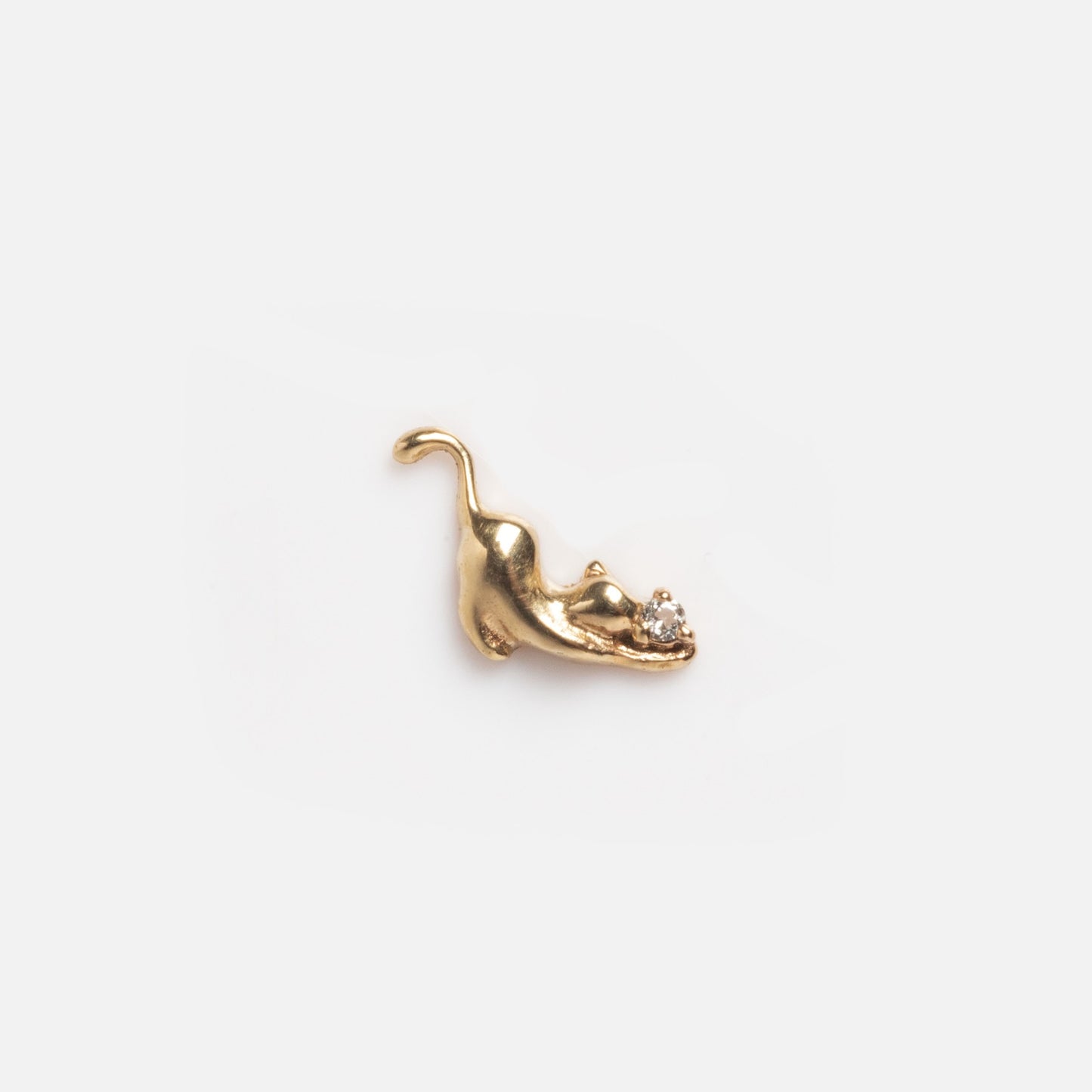 A solid gold tiny lucky charm for a glass charm locket, featuring a playful cat stretching with its tail up and holding a clear round gemstone—an adorable good luck accessory on a plain white background.