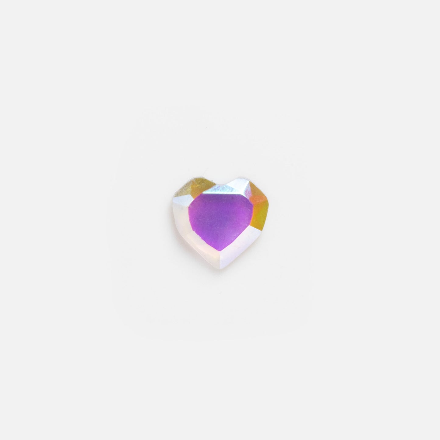 A heart-shaped, purple iridescent gem sits next to the Solid Gold Tiny Lucky Charm for Glass Charm Locket, both displayed on a plain white background.