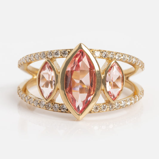 The 14k Alexandrite and Diamond Sun Ring features a large marquise-cut alexandrite centerpiece, two smaller marquise-cut stones, and dual gold bands adorned with sparkling diamonds.