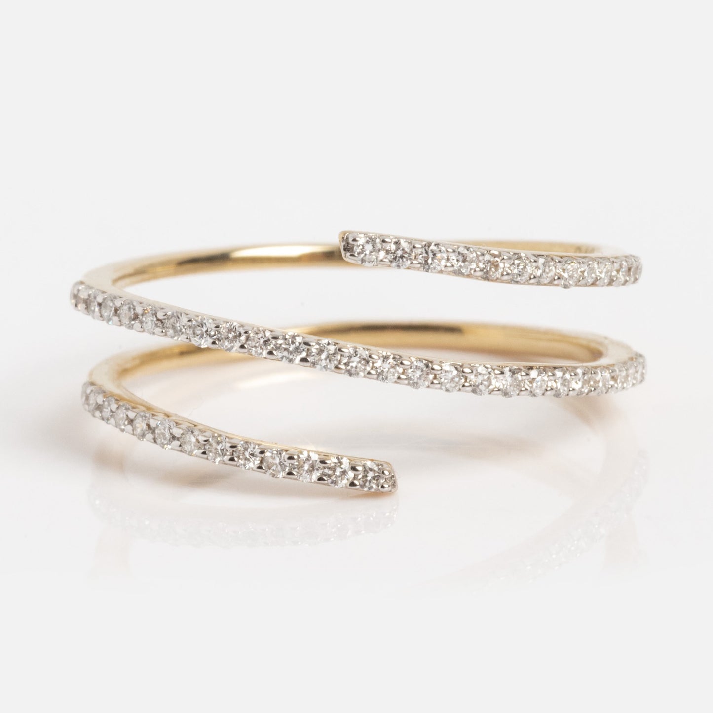 The Solid Gold Shifting Shimmer Diamond Wrap Ring features three overlapping open ends encrusted with small diamonds, arranged in a spiral design and displayed on a white background.