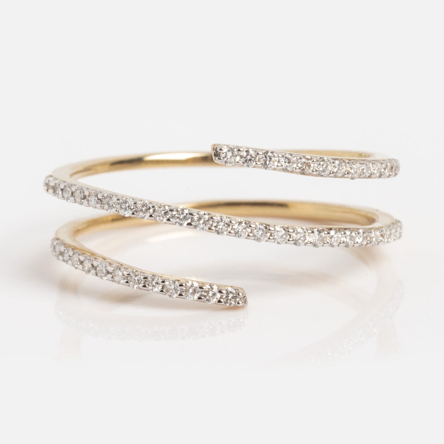 The Solid Gold Shifting Shimmer Diamond Wrap Ring features three overlapping open ends encrusted with small diamonds, arranged in a spiral design and displayed on a white background.