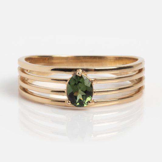 The Solid Gold Stacked Horizon Tourmaline Ring features three parallel gold bands and an oval green tourmaline centerpiece, displayed on a plain white background.