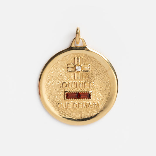 The 14k Vintage Revival Qu'hier Que Demain Pendant Charm is a round gold pendant featuring a small cross at the top, engraved with "OU HIER QUE DEMAIN," and accented by a small rectangular red detail below the cross.