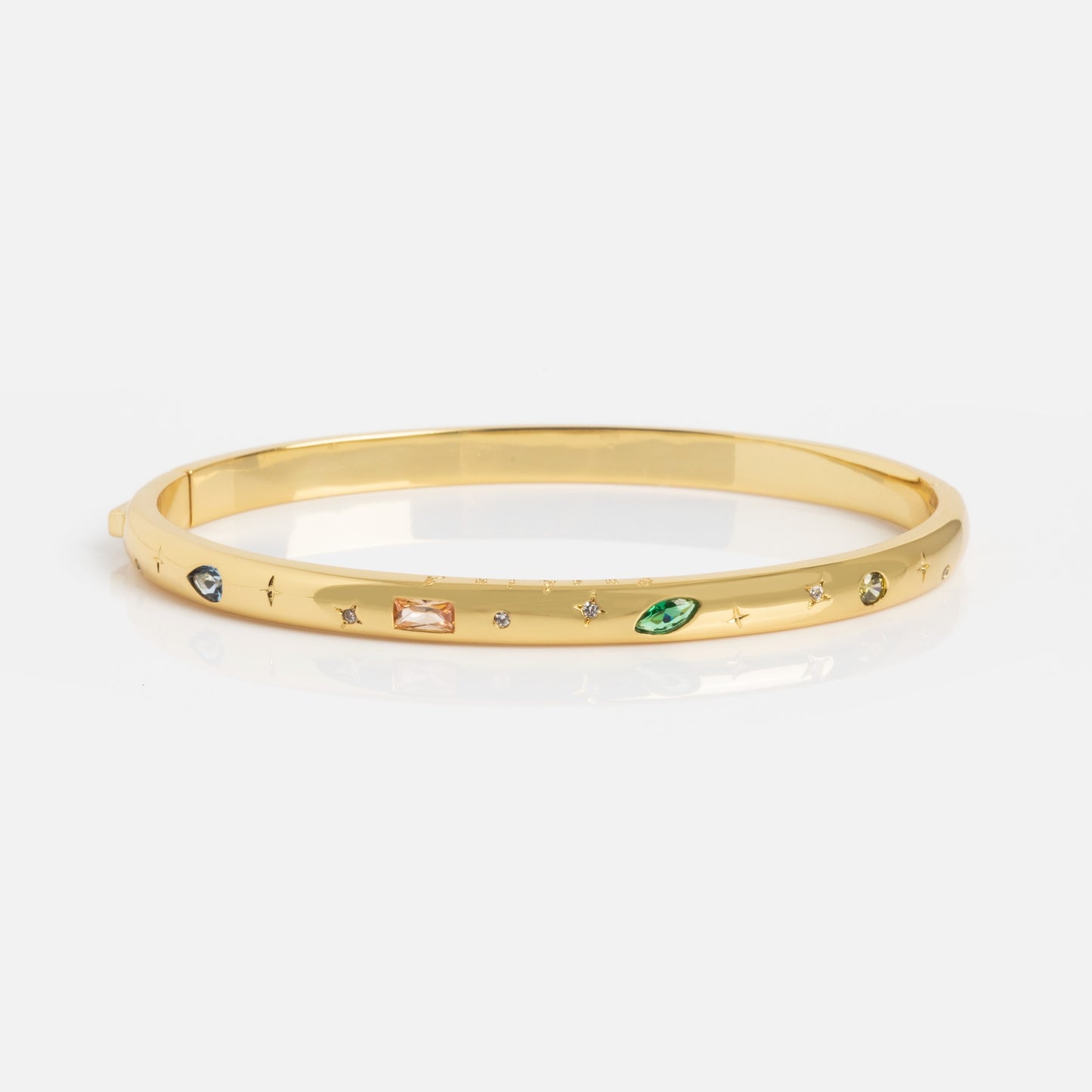 The Hidden Curse Word Fuck Off Bracelet is a gold bangle featuring assorted small gemstones in green, orange, and clear hues set around its surface, displayed on a plain white background.