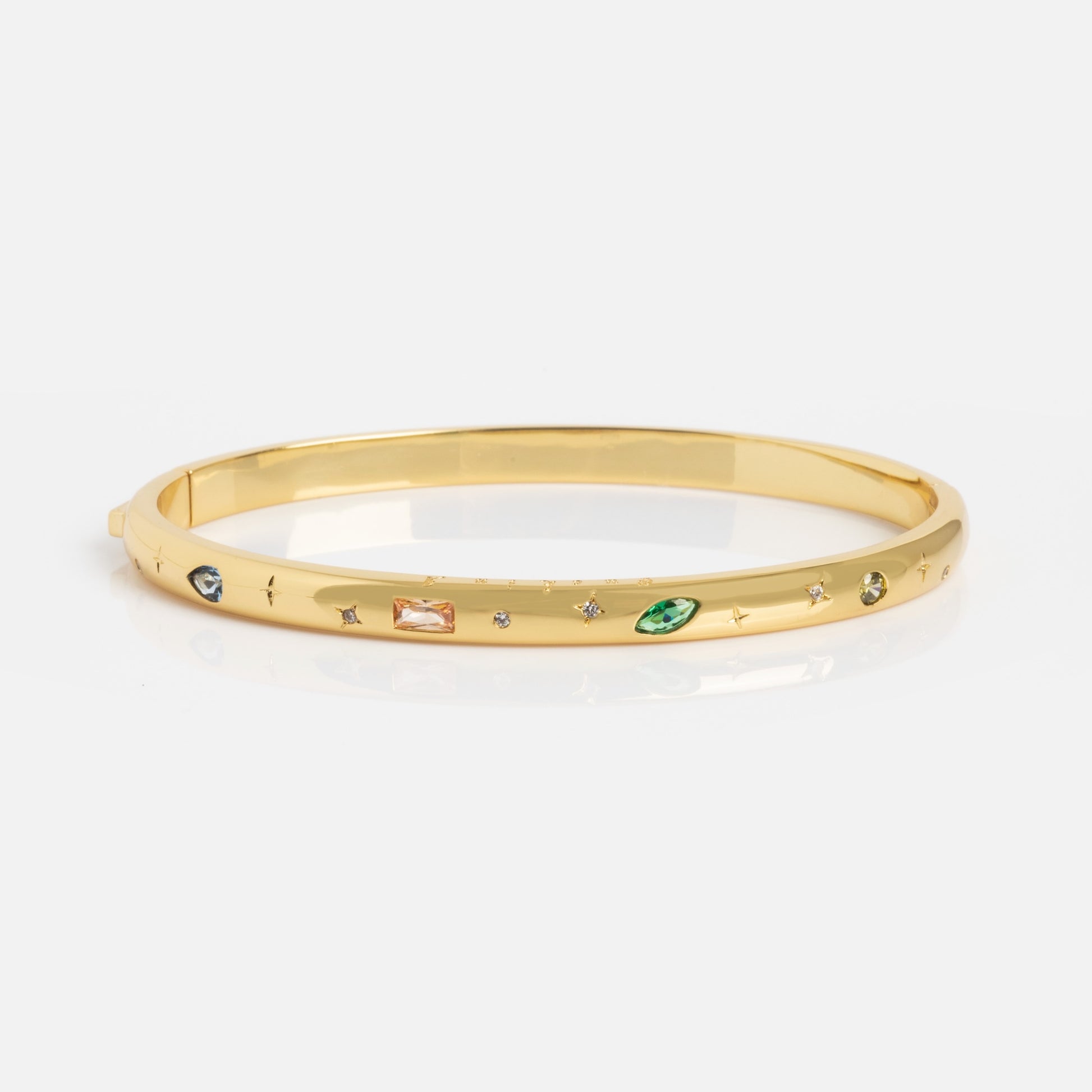 The Hidden Curse Word Fuck Off Bracelet is a gold bangle featuring assorted small gemstones in green, orange, and clear hues set around its surface, displayed on a plain white background.