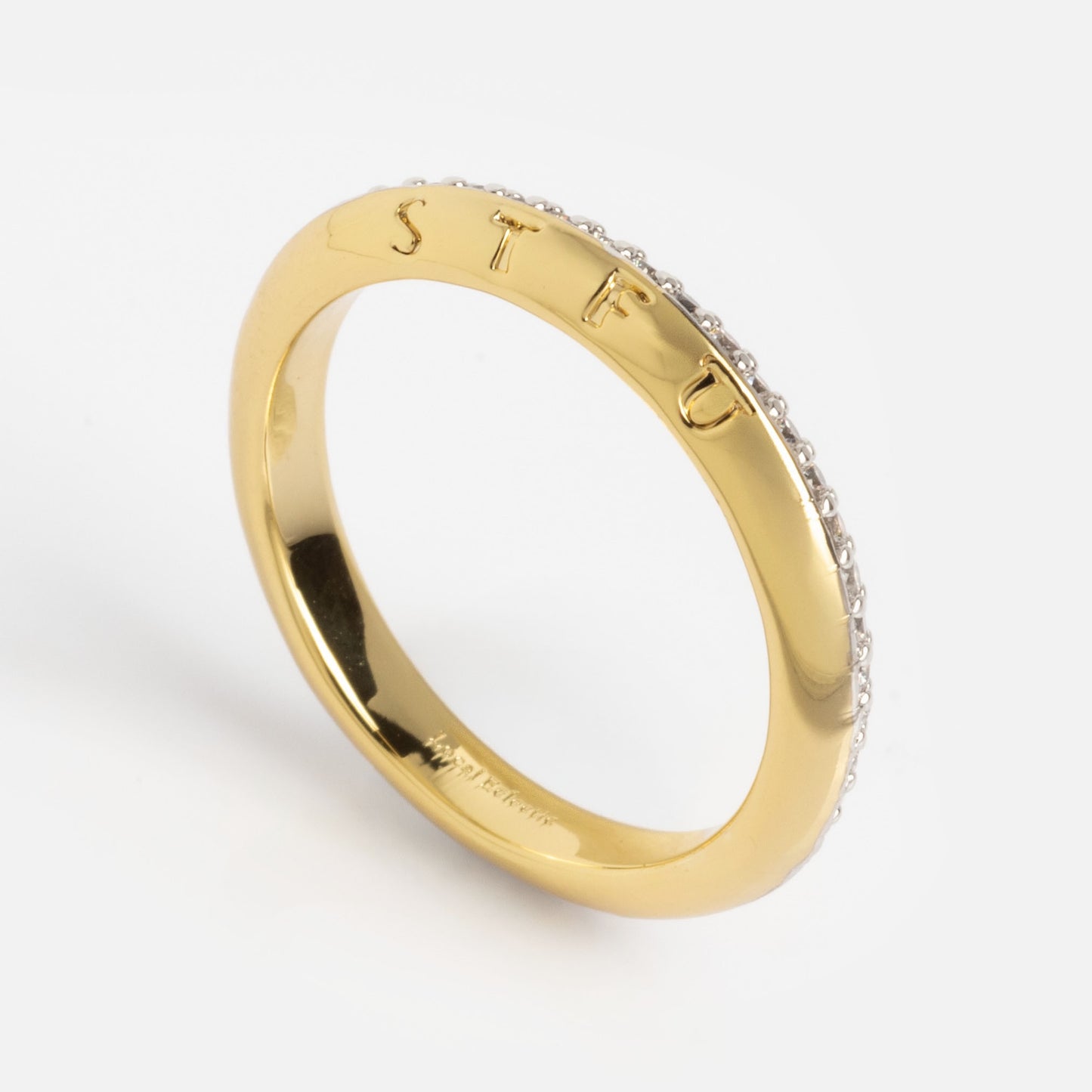 The Hidden Curse Word STFU Ring is a gold band with "STFU" engraved on the outside and a row of small clear gemstones along one edge, shown against a plain white background.