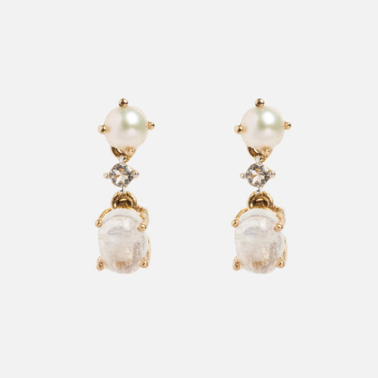 The Solid Gold Soft Glow Pearl and Moonstone Drop Studs feature a round pearl at the top, white topaz accents in the middle, and an oval-shaped moonstone dangling at the bottom.