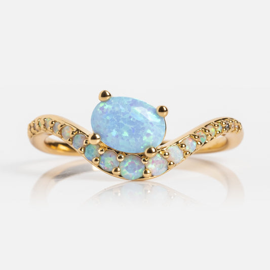 The Main Character Floating Ombre Birthstone Ring showcases a large oval center gem with a curved band of smaller stones, creating a graceful, elegant look against a white background.