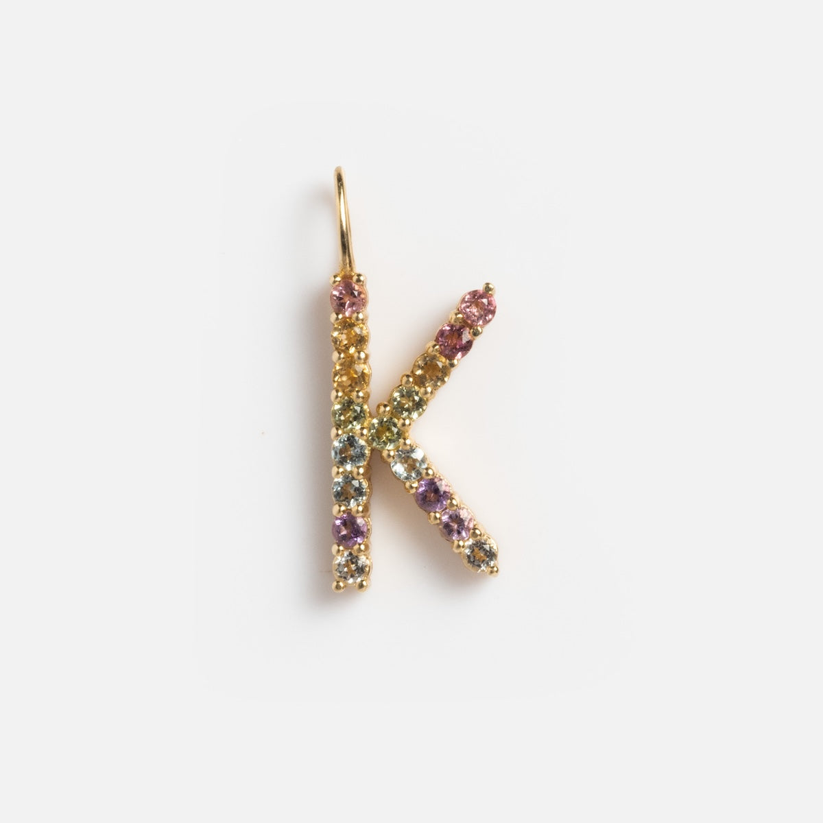 The Solid Gold Pastel Gemstone Letter Charm Sample features a K pendant in 9k yellow gold, accented with delicate pink tourmaline and multicolored gemstones, displayed on a plain white background.
