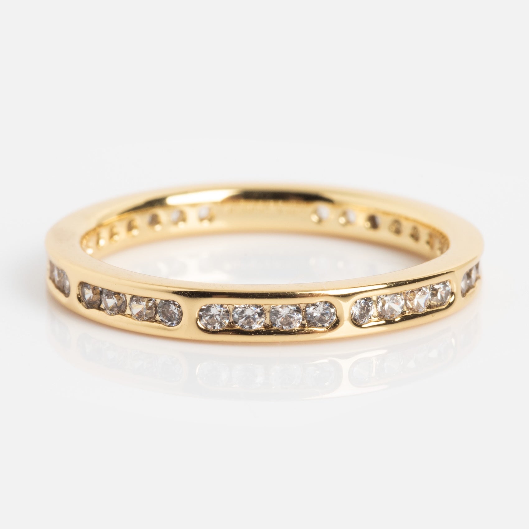 The Bold Eternity Stacking Ring features small round diamonds set in rectangular segments around the gold band, shown on a white background.