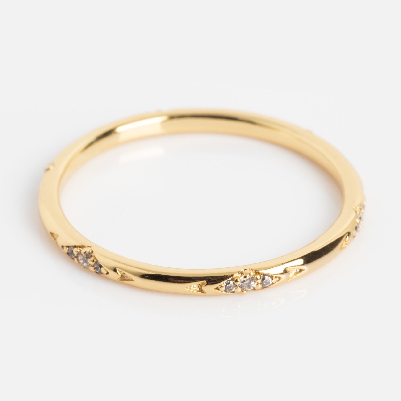 The Dainty Flicker Stacking Ring features small, round clusters of clear gemstones spaced evenly around a thin gold band, displayed on a plain white background.