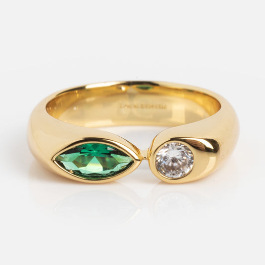 The Bold Toi Et Moi Pinky Ring showcases a marquise-cut green gemstone and a round white diamond side by side on a polished gold band, displayed against a white background.