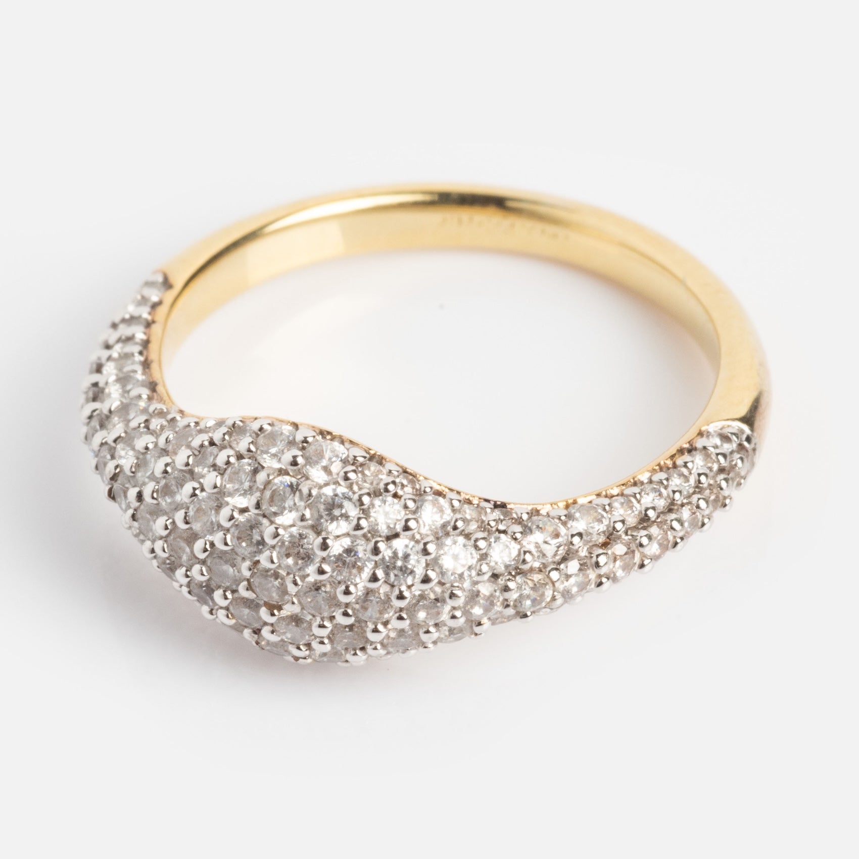 The Pave Signet Pinky Ring features a curved gold top adorned with multiple small, sparkling diamonds, shown against a white background.