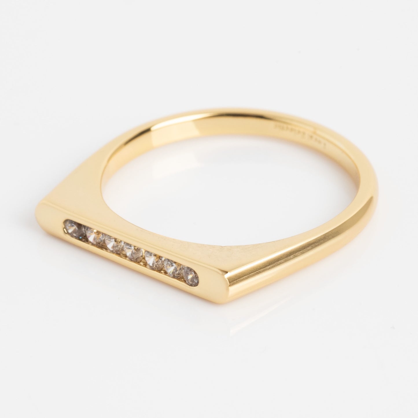 The Pave Bar Pinky Ring showcases a flat gold band with a row of small, round white diamonds set in a straight line. Photographed against a white background.