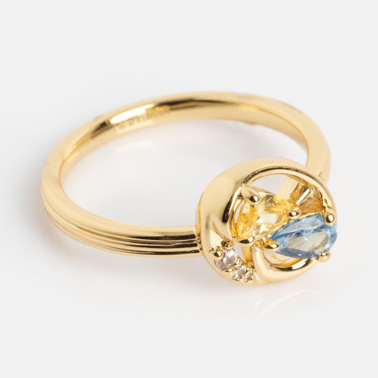 The Eclectic Swirl Pinky Ring is a gold ring with a round setting, showcasing yellow and blue marquise-cut stones alongside two small clear stones in an elegant cluster design.