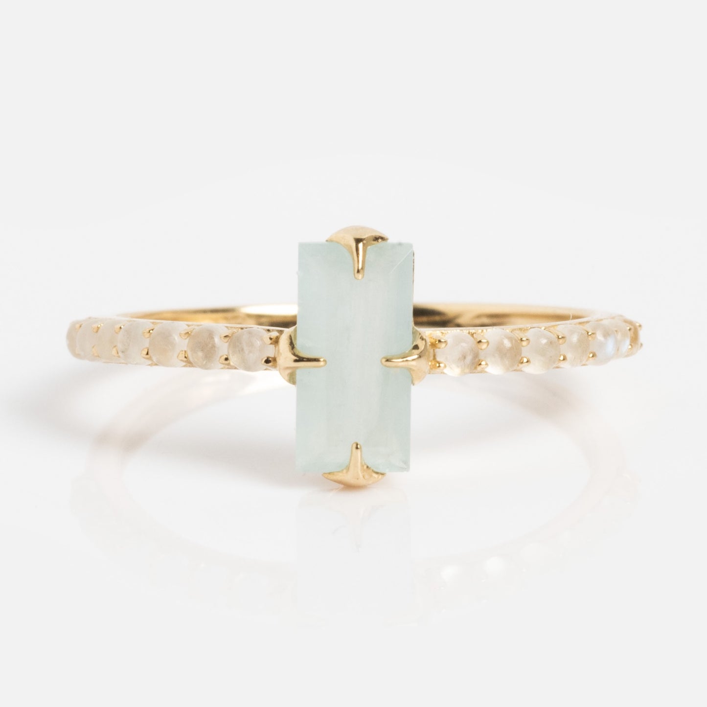 The Solid Gold 2026 March Capsule Delicate Aquamarine Solitaire Ring features a vertical rectangular pale green aquamarine at its center, accented by small round stones along a thin gold band.