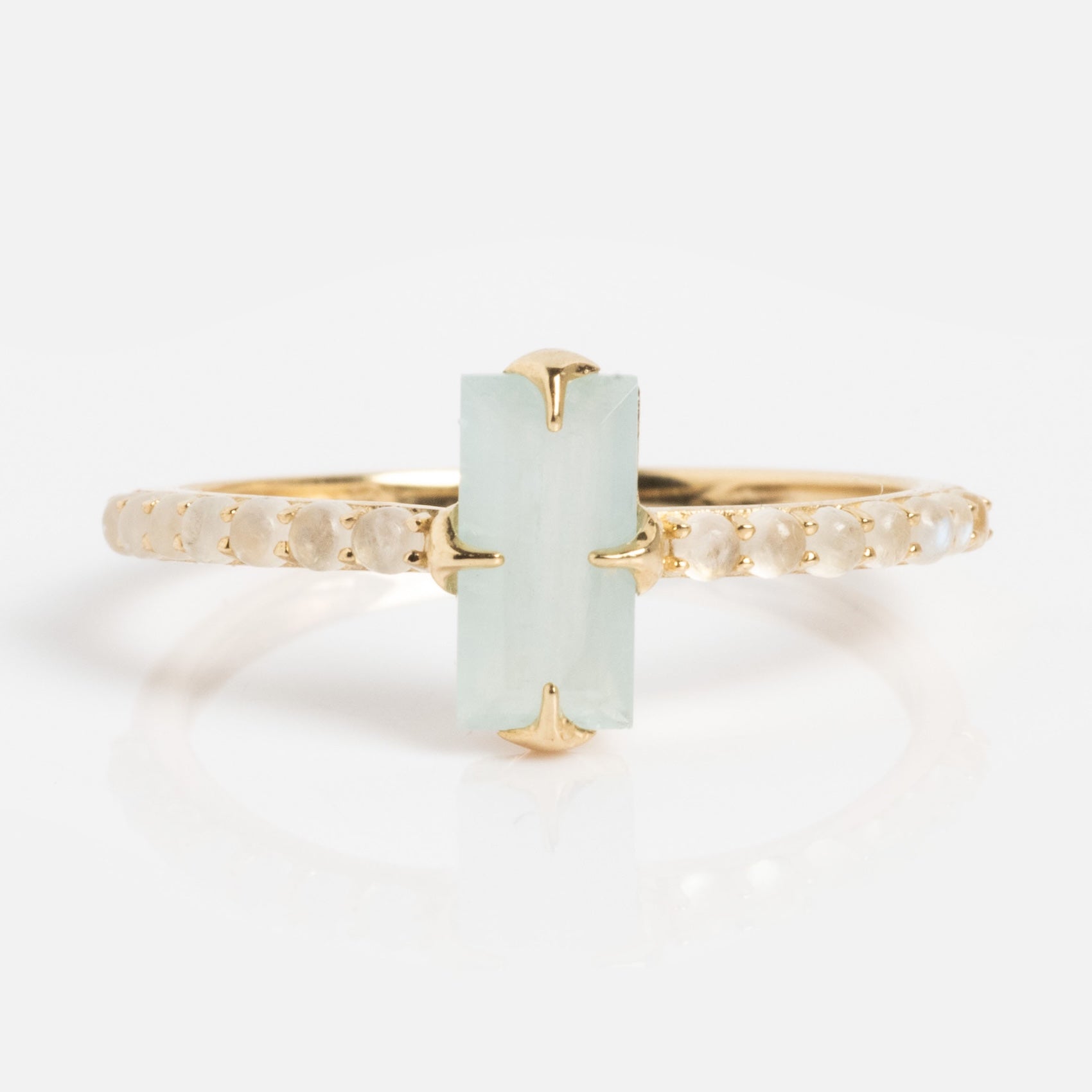 The Solid Gold 2026 March Capsule Delicate Aquamarine Solitaire Ring features a vertical rectangular pale green aquamarine at its center, accented by small round stones along a thin gold band.