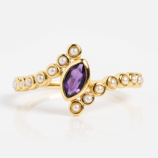 The 2026 February Capsule Floating Amethyst and Pearl Twist Ring showcases a marquise-cut amethyst centerpiece accented by small round pearls elegantly arranged along the gold band.